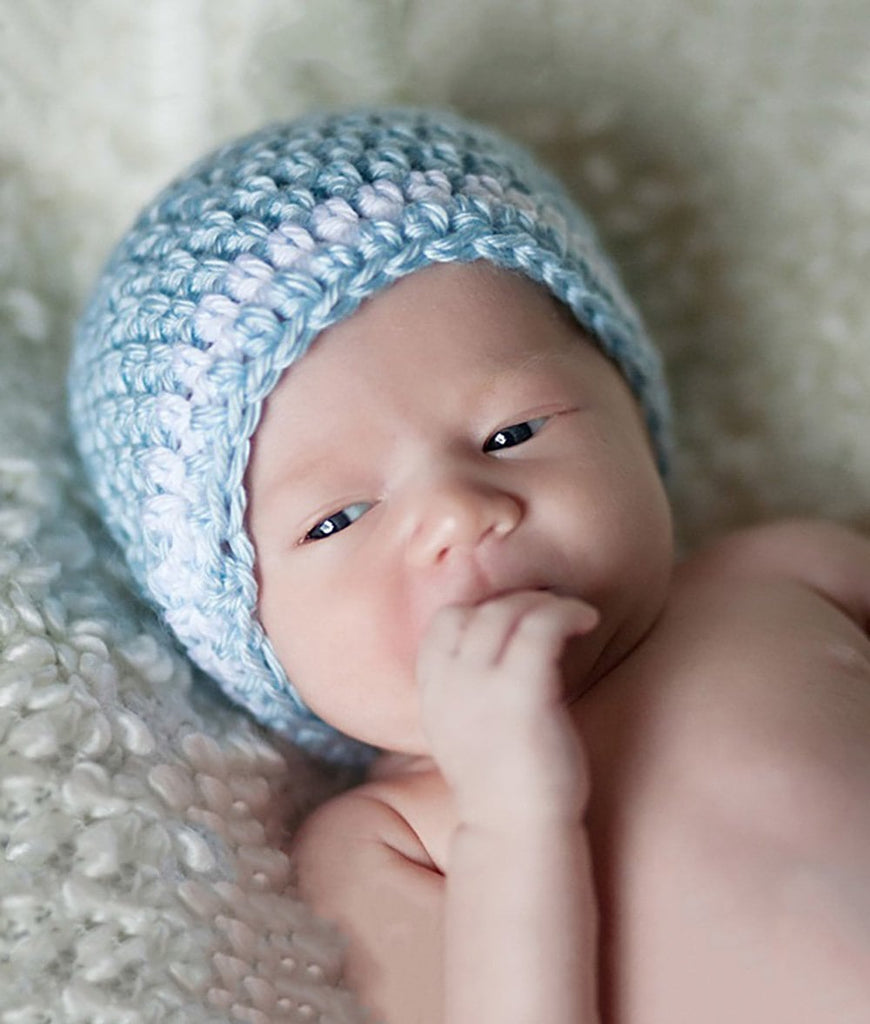 Baby wearing a light blue crochet newborn hat with white stripe