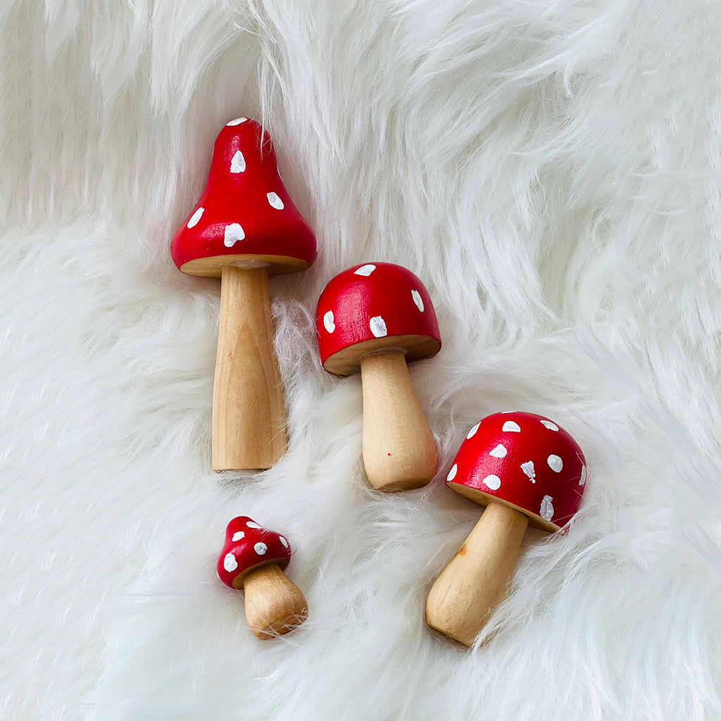 red hand painted wooden mushrooms with white spots