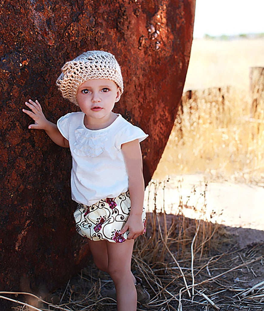 baby girl wearing a tan knit beret hat for toddlers
