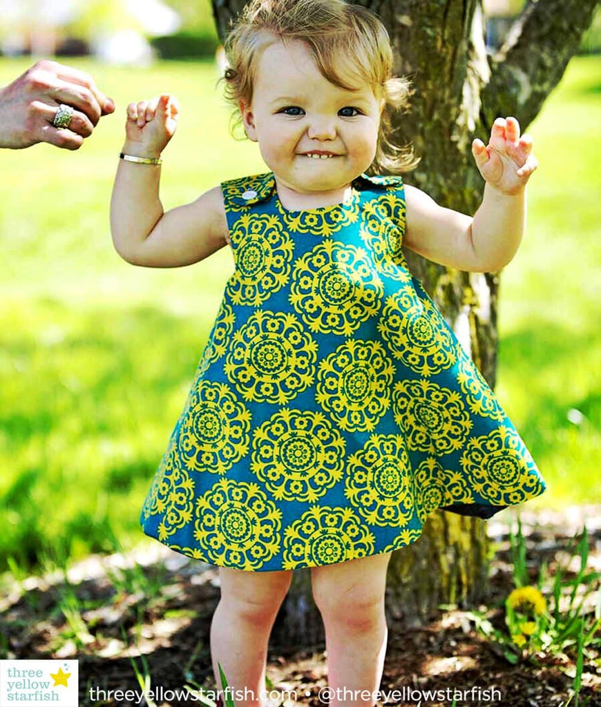 toddler girl wearing a mustard yellow and turquoise dress for girls