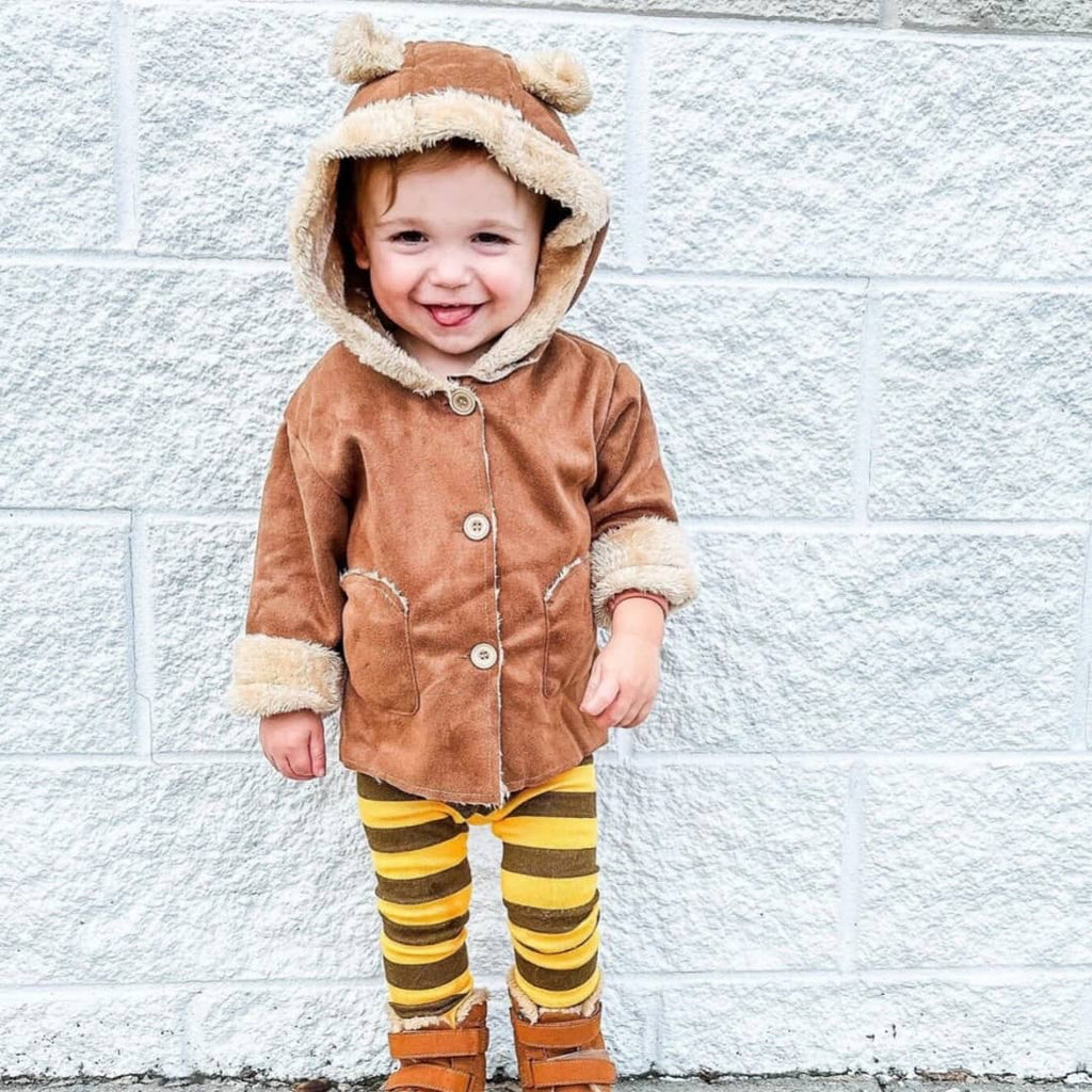 toddler wearing a brown baby bear coat with ears on the hood