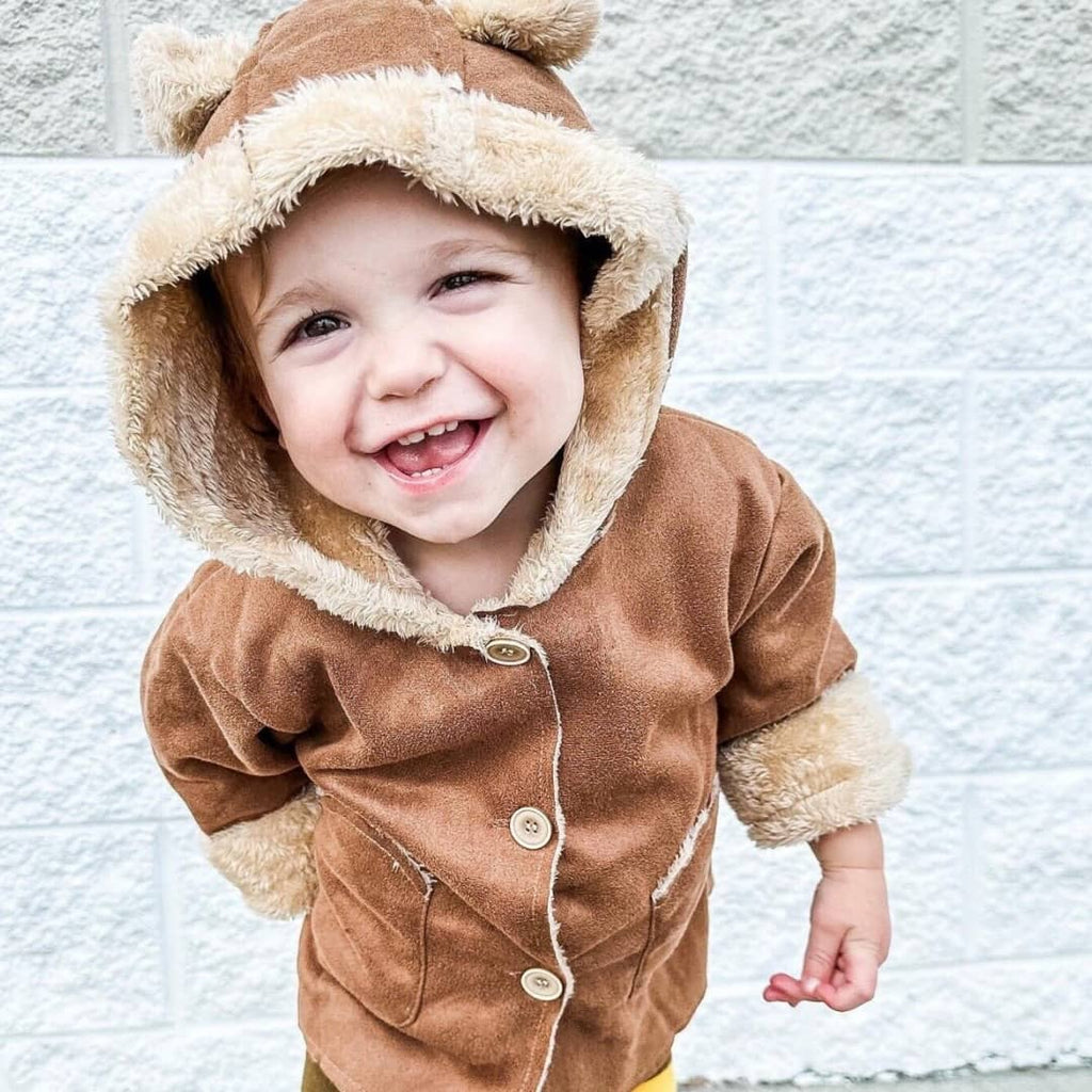 toddler boy wearing a brown fleece lined suede jacket with ears on the hood