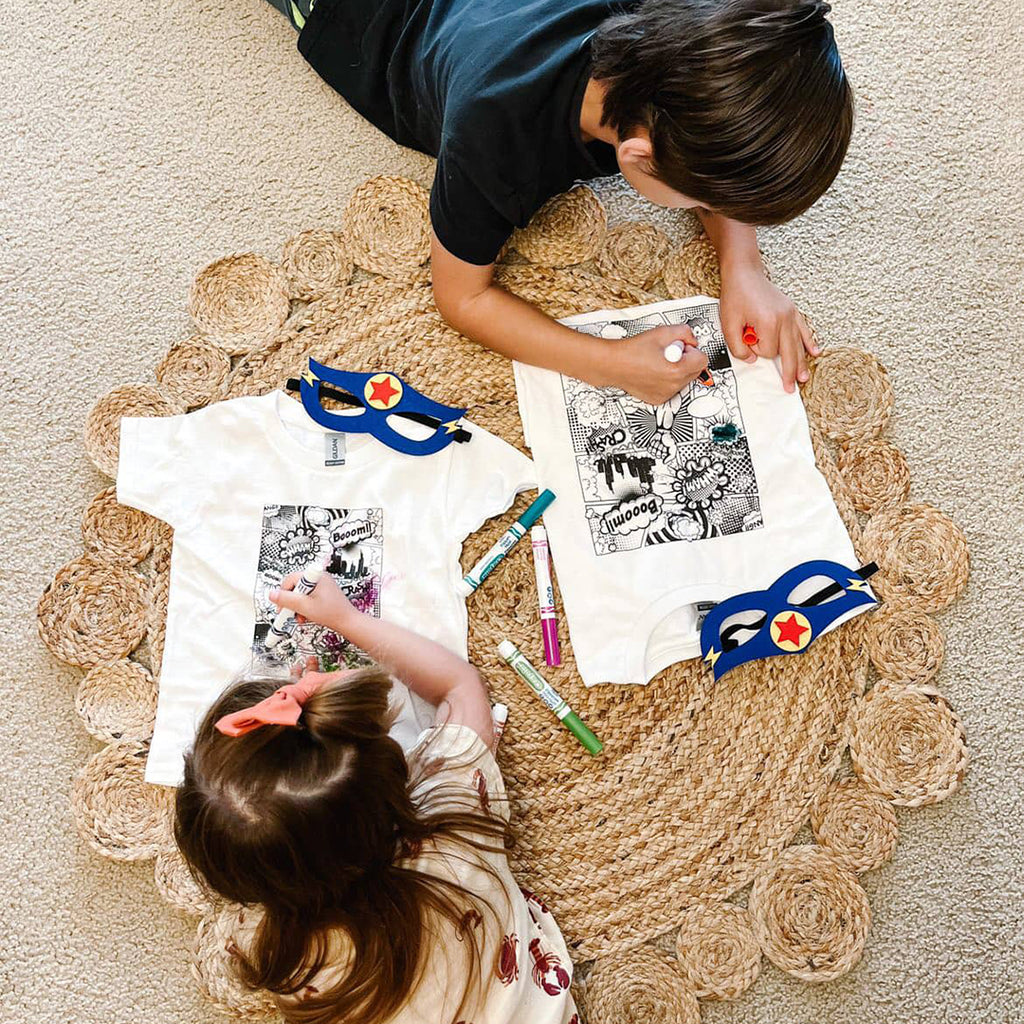 two kids coloring in the DIY superhero party costumes kids activity set