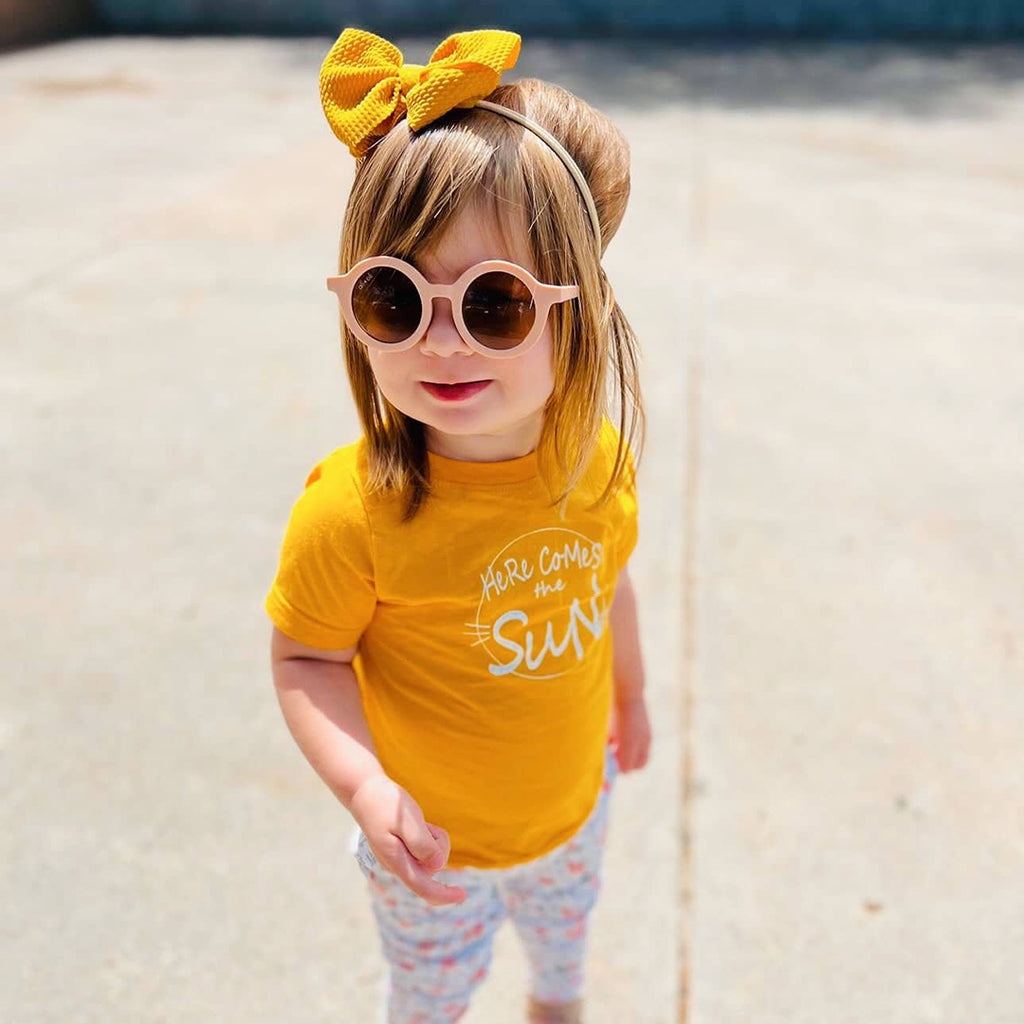 toddler girl wearing a yellow Here Comes The Sun kids shirt