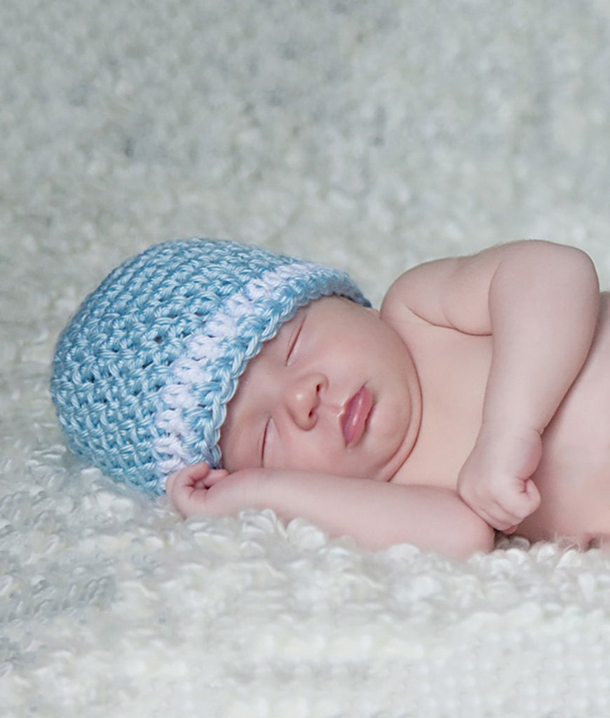 Sleeping infant in light blue crochet newborn hat