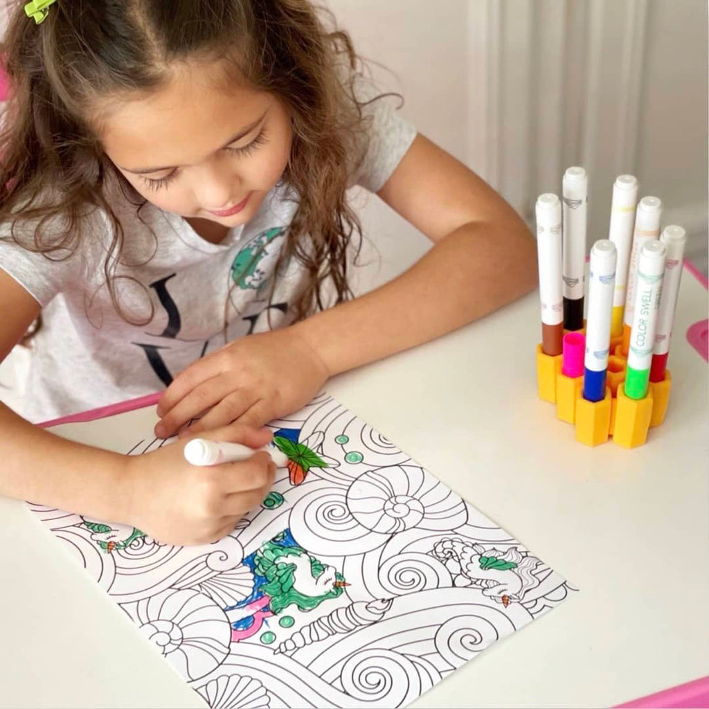 little girl coloring while using her marker organizer