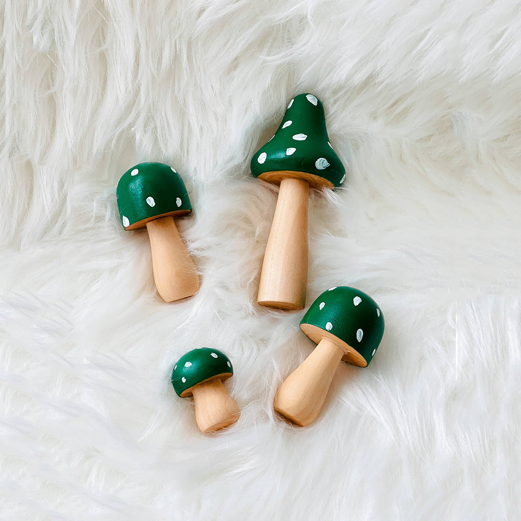 green hand painted wooden mushrooms with white spots