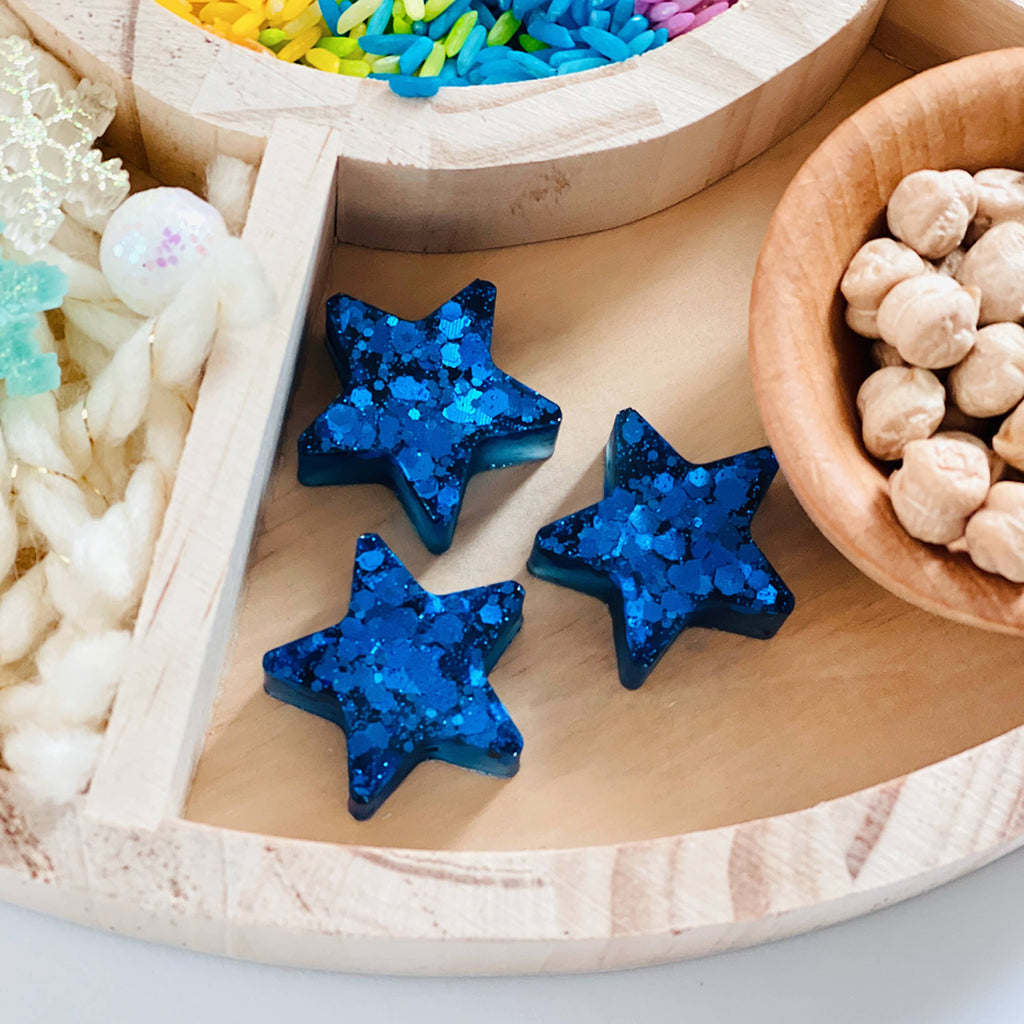 resin star shapes in a weather themed sensory bin for kids