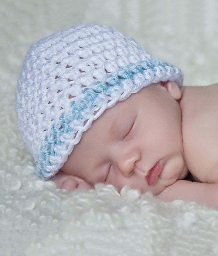 Sleeping infant wearing a white knit beanie hat