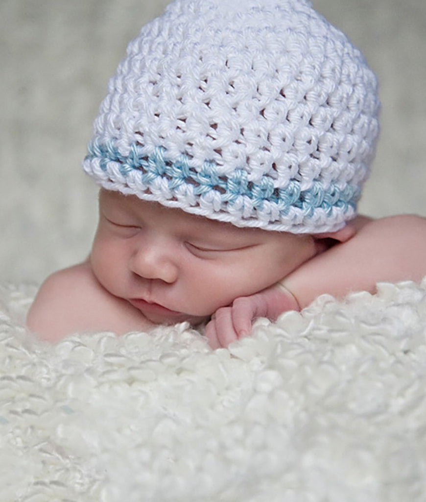 Sleeping baby in a white crochet hat with light blue stripe