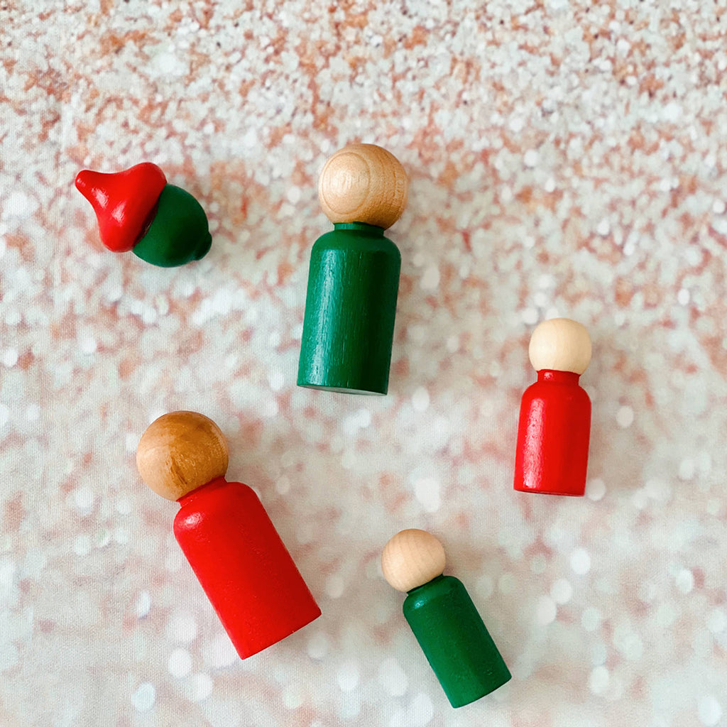 red and green Montessori peg dolls and matching wooden acorn